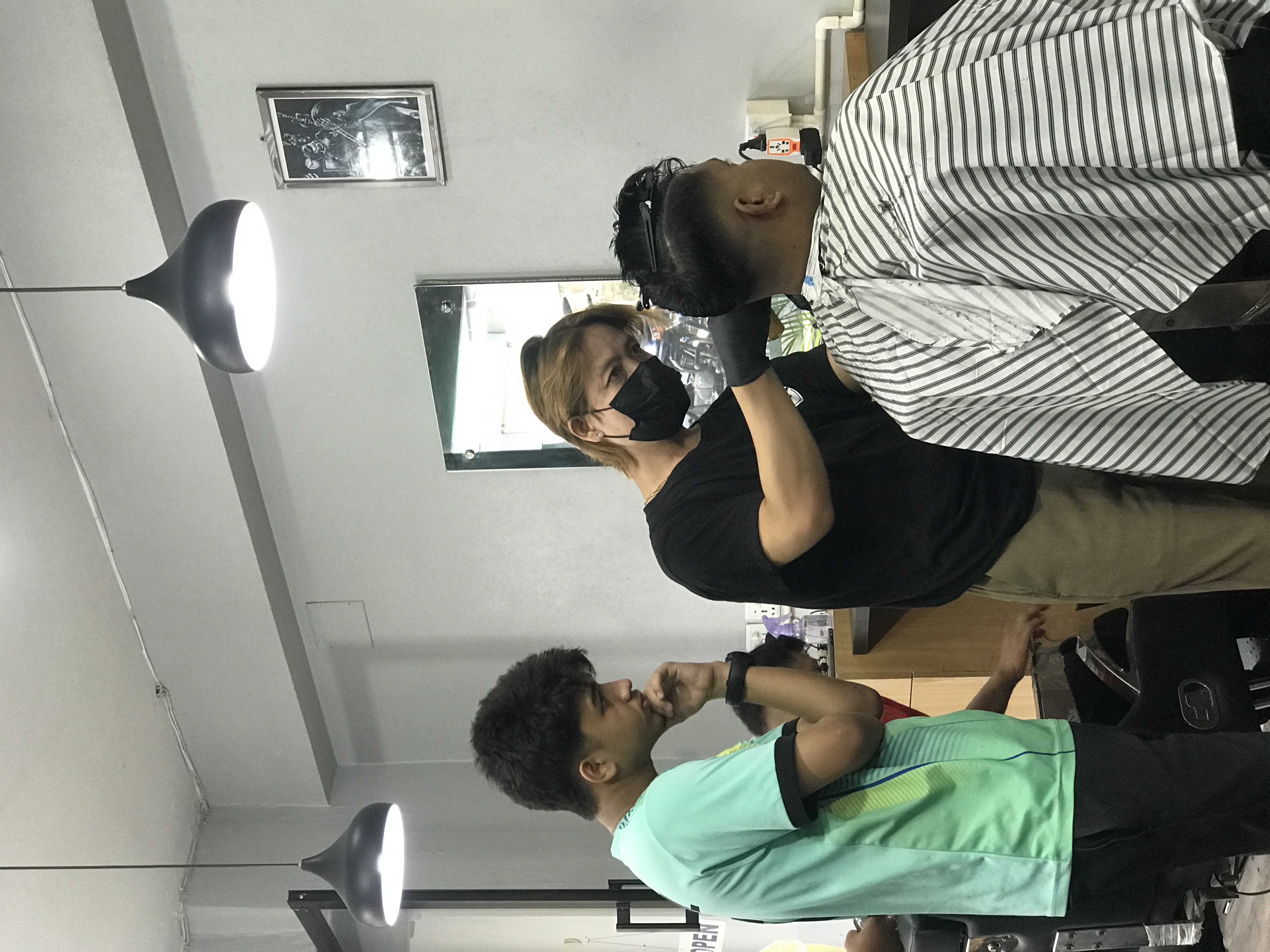 Ayus Gurung working with a client in the barber shop