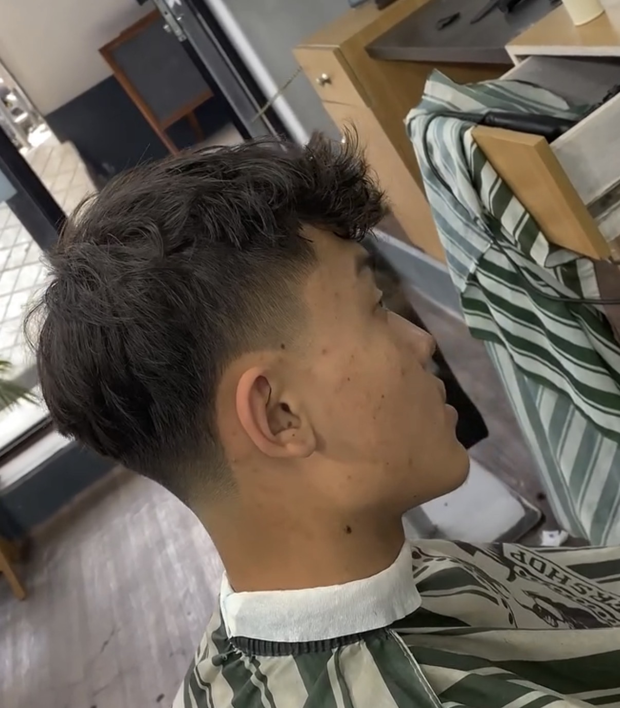 Side view of a textured crop fade haircut in the barber shop