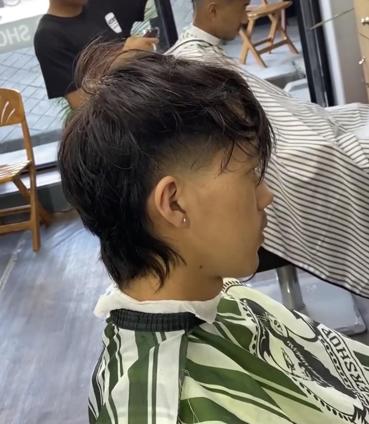 Side view of a longer flow haircut with clean taper work