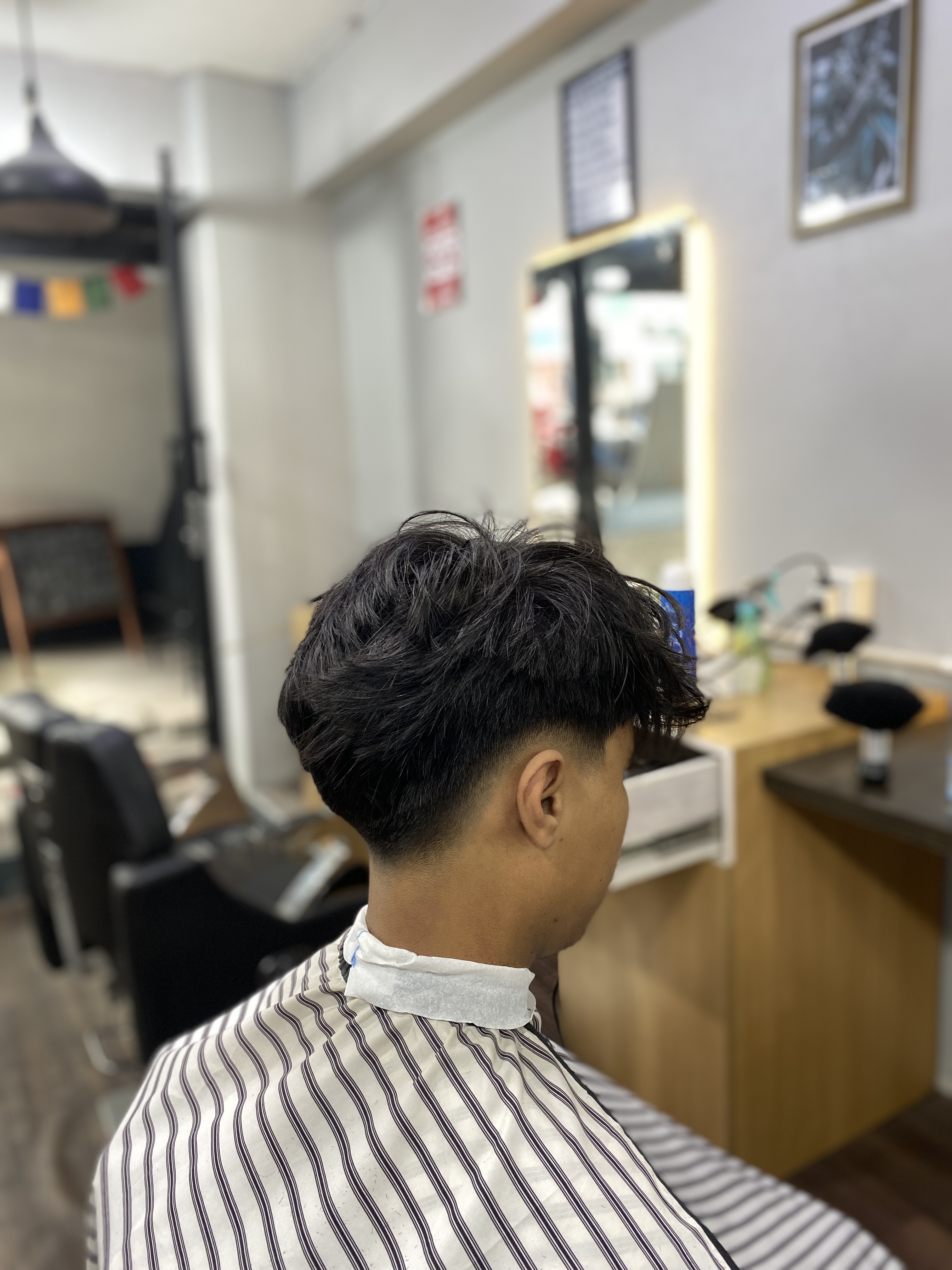 Side back view of a low drop fade haircut with natural flow