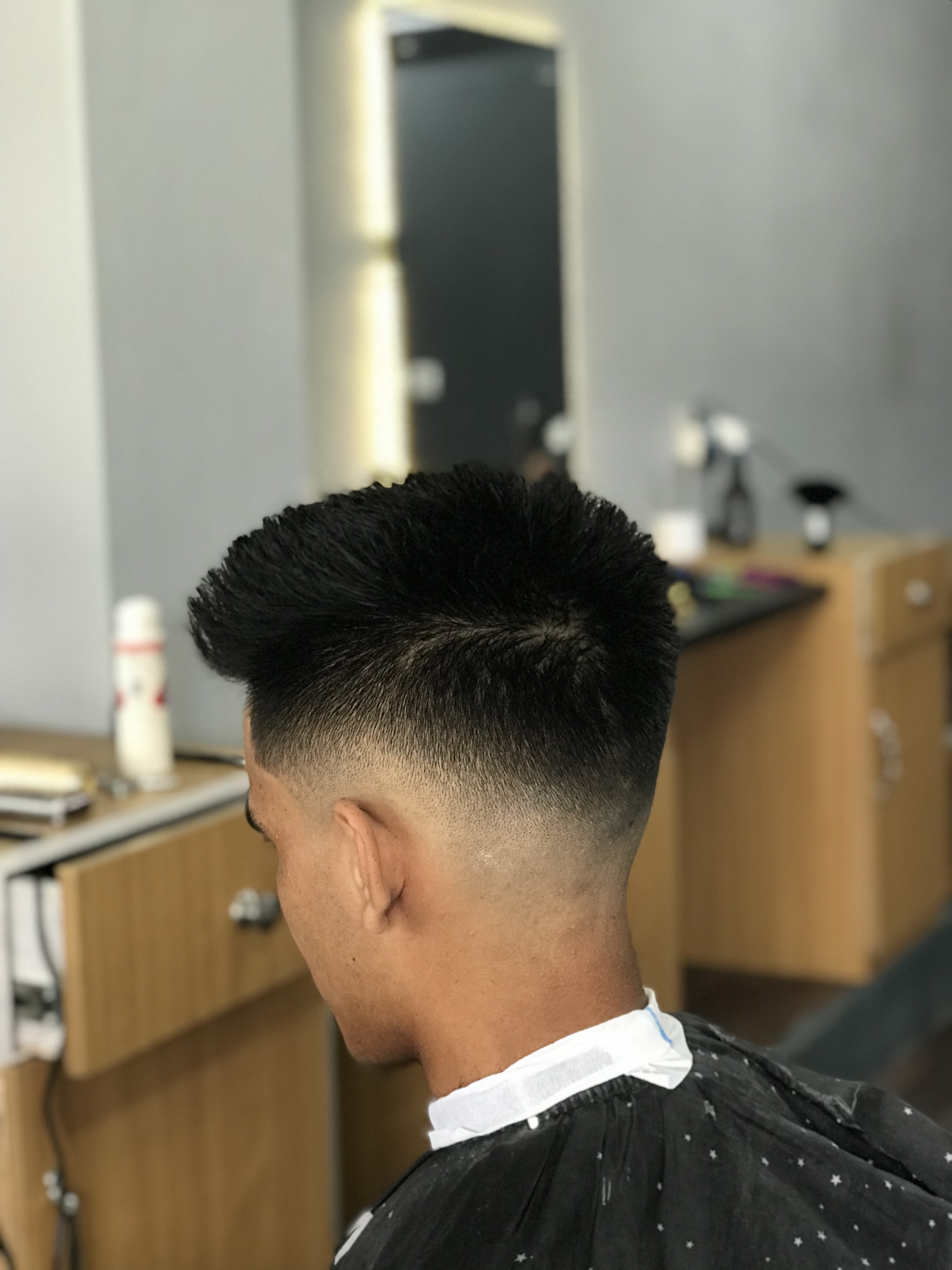 Back side view of a mid fade with a styled top